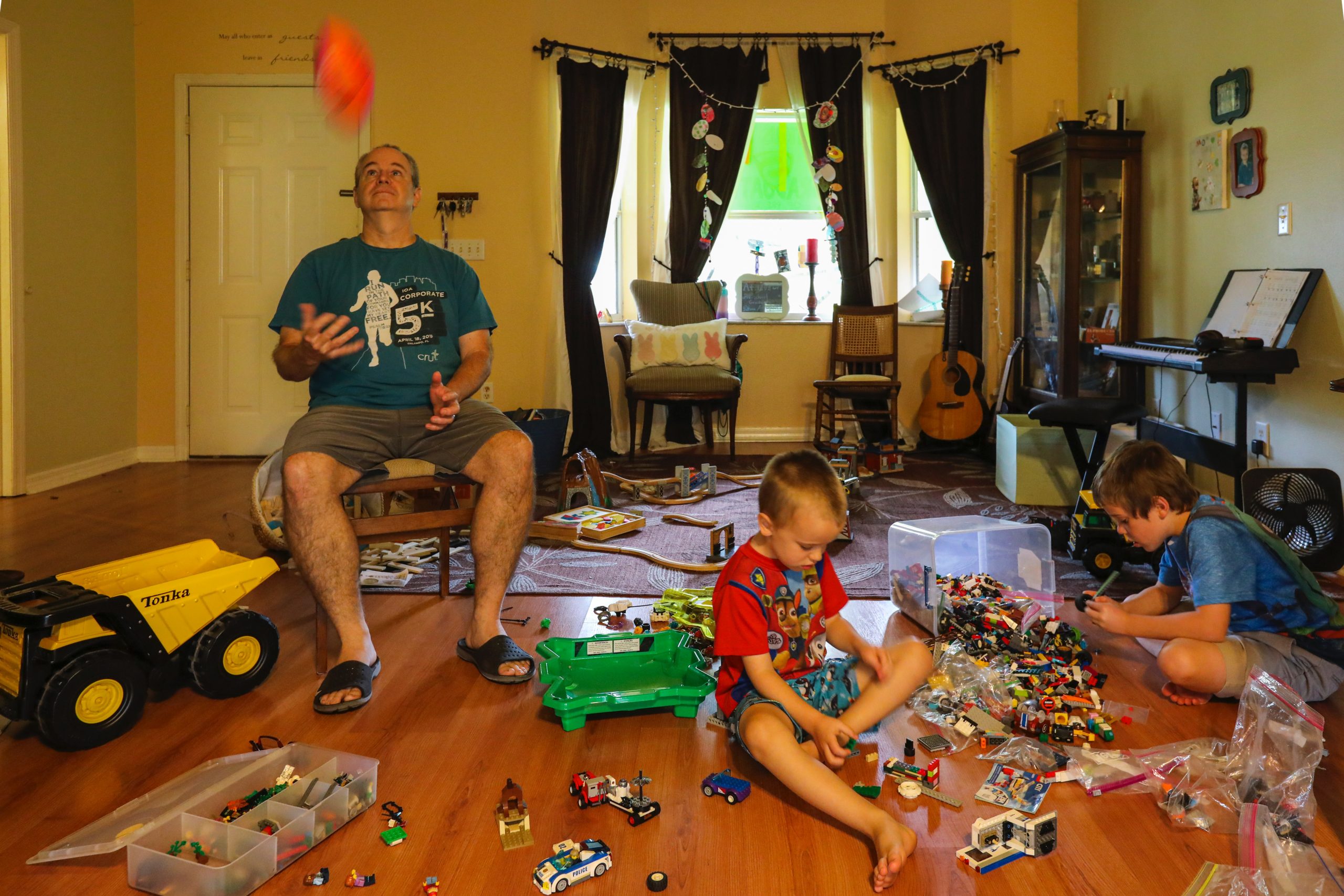 Male parent with kids surrounded by children's toys