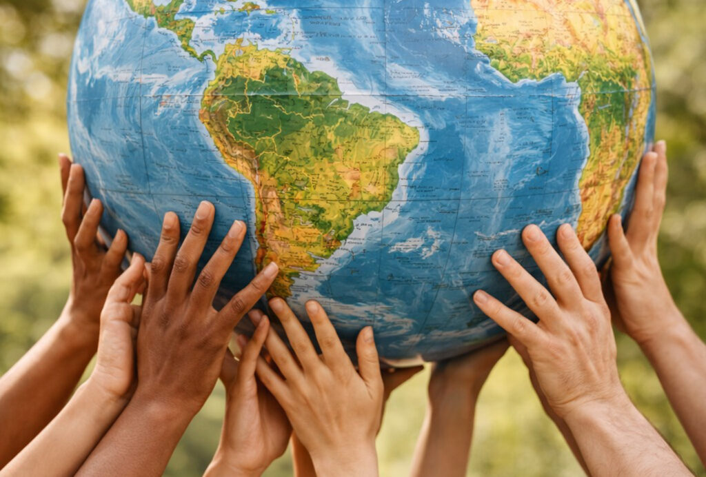 Multiple hands holding up the earth