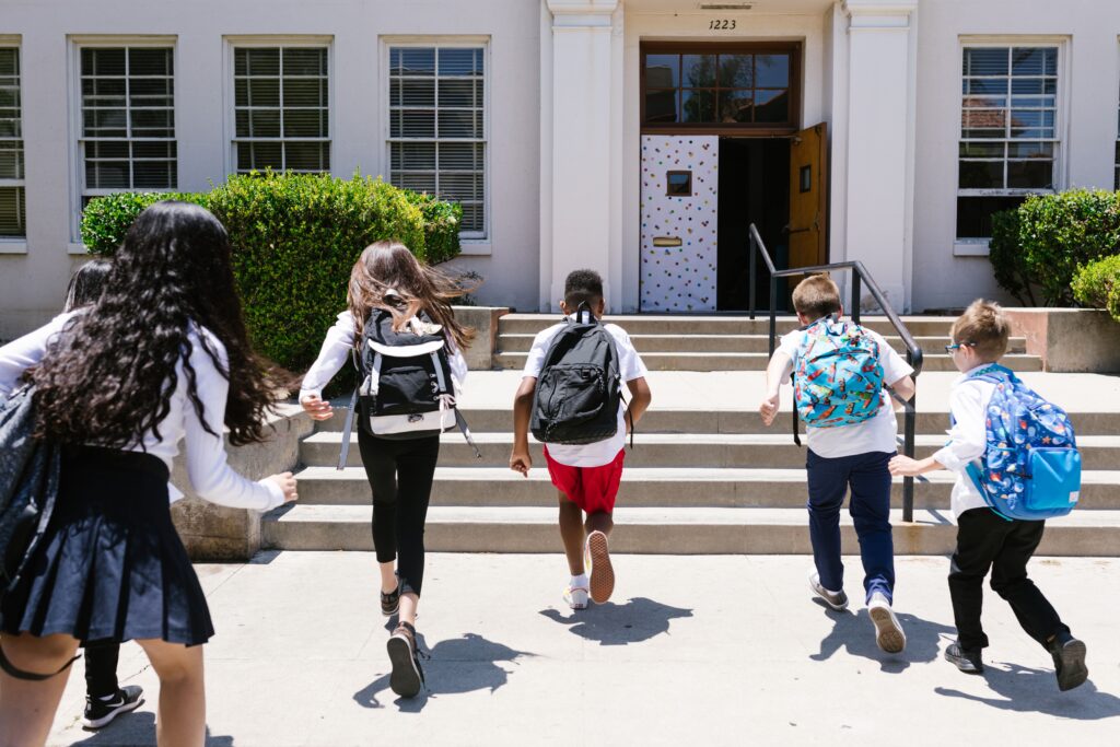 "Children with backpacking running to their school"
